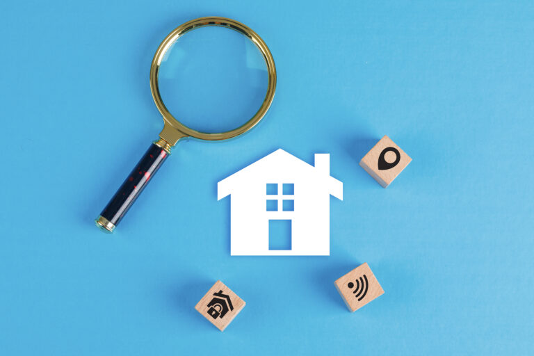 a magnifying glass and home icons on a blue background depicting cost of landlord insurance