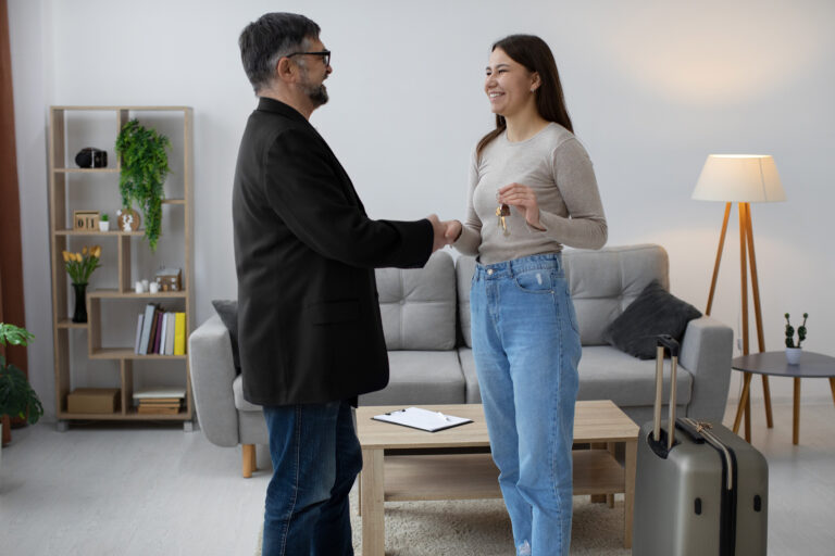 airbnb hosts shake hands and smile inside an airbnb